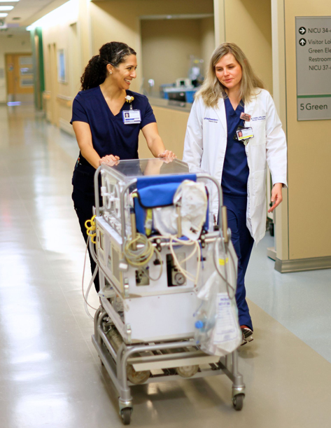 Talking nurses walking in a hallway.