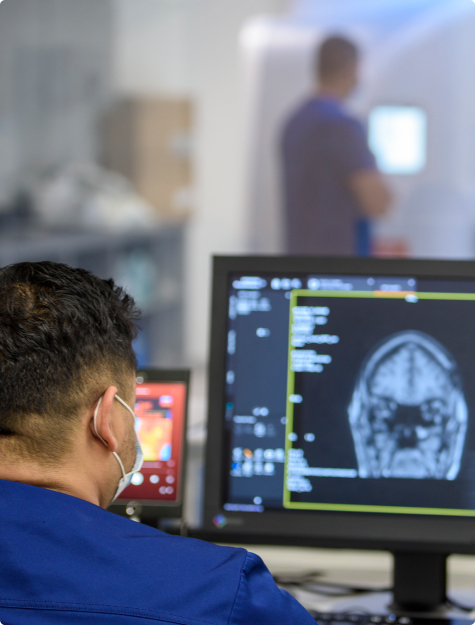 Looking for the shoulder of an MRI Tech looking at an MRI image on a computer screen